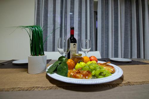 a plate of food on a table with a bottle of wine at Lithines Villa go green in Dhafnés