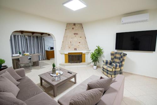 a living room with a couch and a fireplace at Lithines Villa go green in Dhafnés