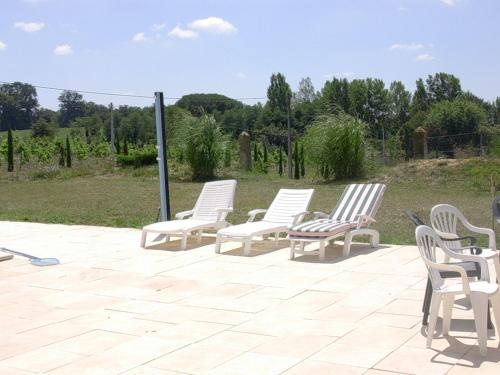 a group of white chairs sitting on a patio at Maison Lalanne in Castelnau-Chalosse