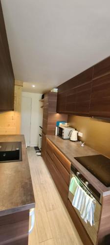 une cuisine avec des armoires marron et un comptoir dans l'établissement Centre Station: Altineige Cosy Appart pour 4, à Val Thorens