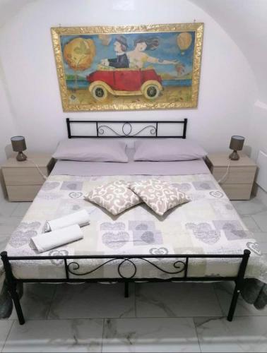 a bedroom with a bed with a painting on the wall at Mory&Clary Cave Palese Airport in Bari Palese