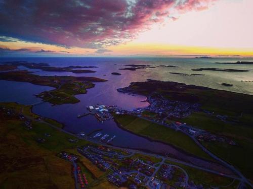 an aerial view of a body of water at sunset at Easterhoull Chalets in Scalloway