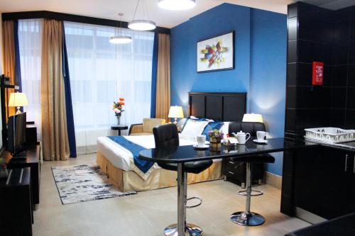 Habitación de hotel con cama y escritorio. en Al Diar Sawa Hotel Apartments en Abu Dabi