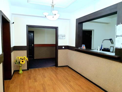 a waiting room with a mirror and a vase of flowers at Gostinochyi Kompleks Hillary in Temirtaū