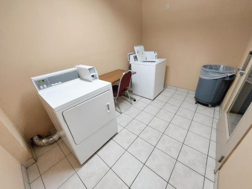 a laundry room with two machines and a trash can at Ramada by Wyndham Reno Hotel & Casino in Reno