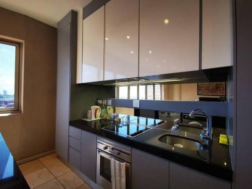 cocina con fregadero y encimera en 1007-Stunning Studio apt with incredible Joburg views, en Johannesburgo