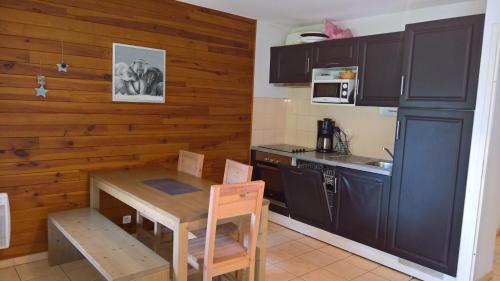 - une cuisine avec une petite table, une table et des chaises dans l'établissement Le Belvédère, à Saint-Mamet
