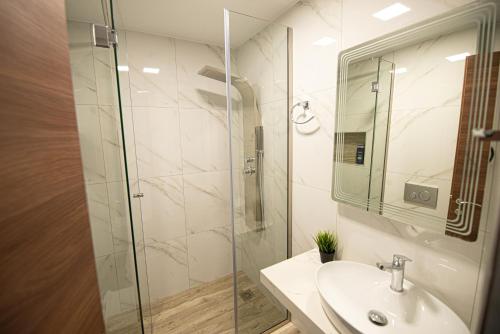 W łazience znajduje się umywalka i przeszklony prysznic. w obiekcie Lithines Villa go green w mieście Dhafnés