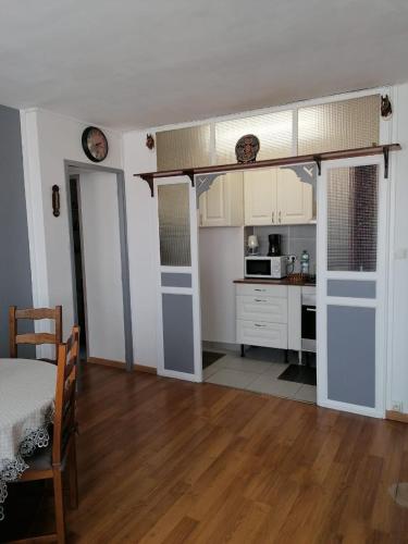 - une cuisine avec des placards blancs et un lit dans une chambre dans l'établissement Dadla, à Marseille
