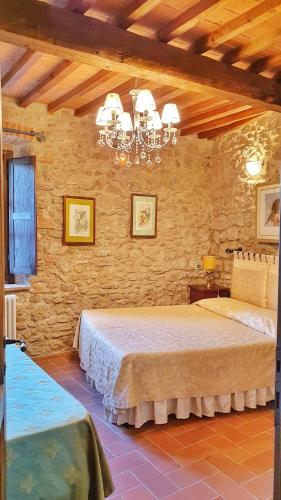 a bedroom with a large bed in a stone wall at Molino dei Preti in Asciano
