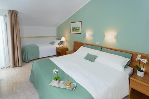 een hotelkamer met 2 bedden en een bed sidx sidx sidx bij Hotel Roma in Palmanova