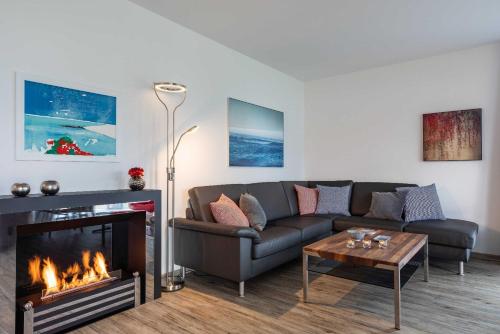Una sala de estar con un sofá y una chimenea. en Appartement "Seeadler" - Oase am Haff, en Garz