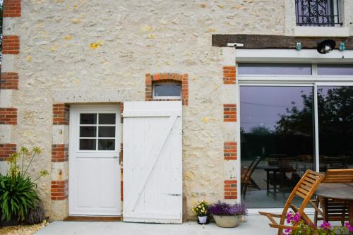 a white garage door on the side of a building at Gîte des ouches - piscine in Civray