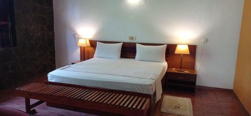 a bedroom with a bed with two lamps on it at The Rock House in Katunayake
