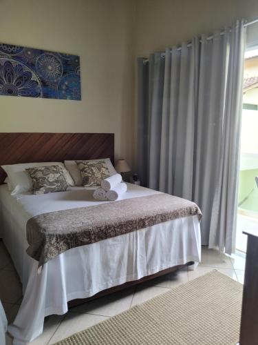 1 dormitorio con cama y ventana en Mares de Camburizinho, en Camburi