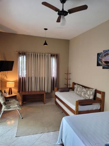 a bedroom with a bed and a ceiling fan at Mares de Camburizinho in Camburi