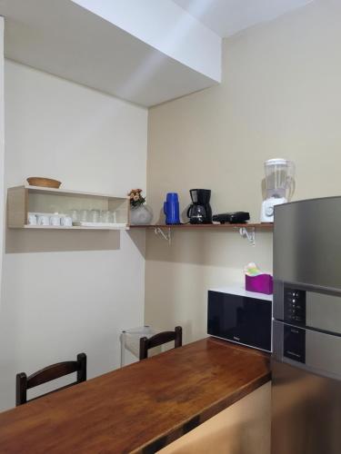 a kitchen with a wooden table and a refrigerator at Mares de Camburizinho in Camburi