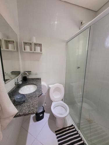 a bathroom with a toilet and a sink and a shower at Mares de Camburizinho in Camburi