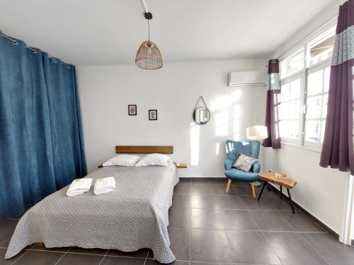 - une chambre avec un lit et une chaise bleue dans l'établissement Charmant pied-à-terre coeur de ville, à Pointe-à-Pitre