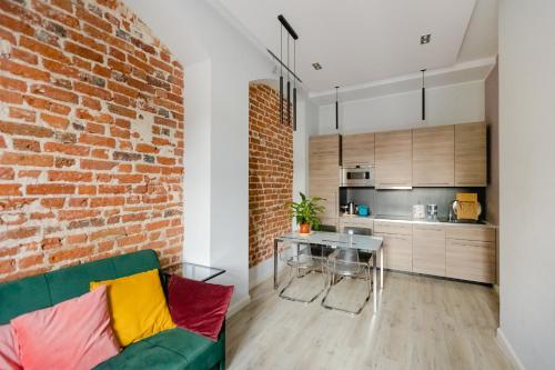 a living room with a brick wall and a green couch at Apartament Rynek in Wrocław