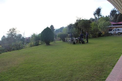 a group of people standing in a grass field at Maa Anand Mayee Guest House in Panuānaula