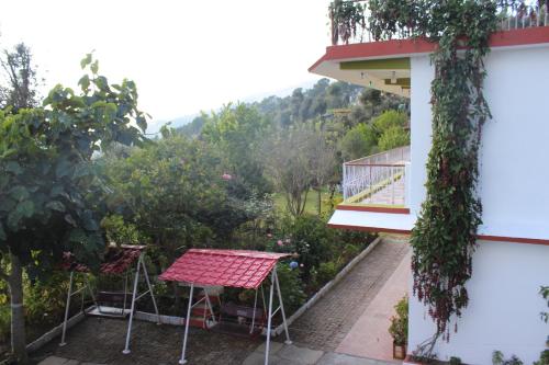 a balcony of a house with a table and a view at Maa Anand Mayee Guest House in Panuānaula