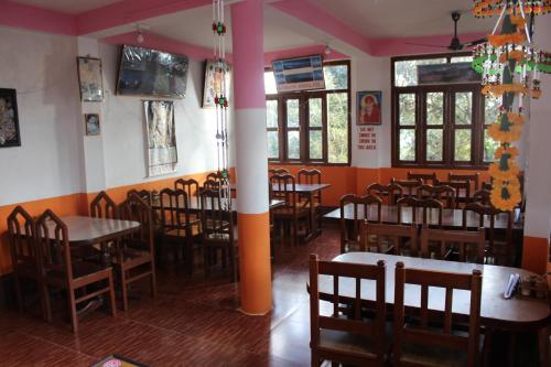 a dining room with tables and chairs in a restaurant at Maa Anand Mayee Guest House in Panuānaula