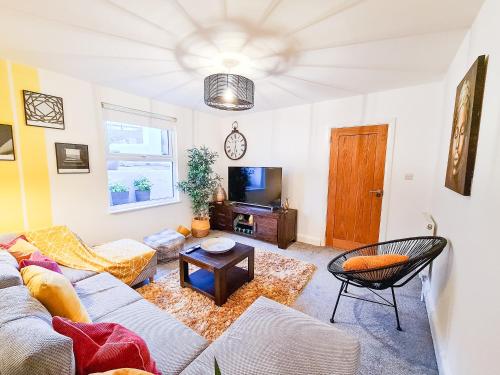 a living room with a couch and a tv at 4bd Hidden gem by Brighton Station in Brighton & Hove