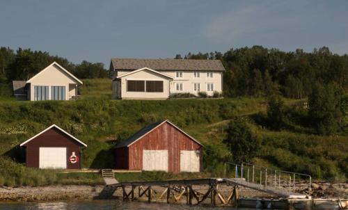 a house on a hill next to a body of water at Nice little house right by the sea, stunning view in Renså