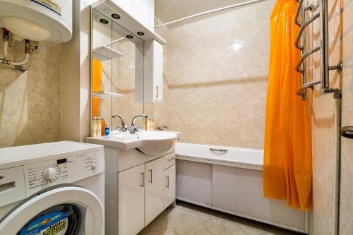 a bathroom with a washing machine and a sink at Most City area 1-bedroom apartment, central in Dnipro