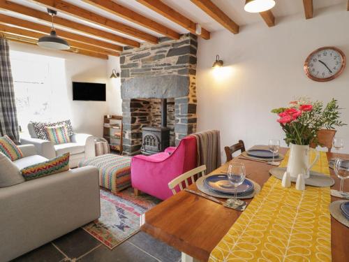 a living room with a table and a fireplace at Pen y Cwm in Penmachno