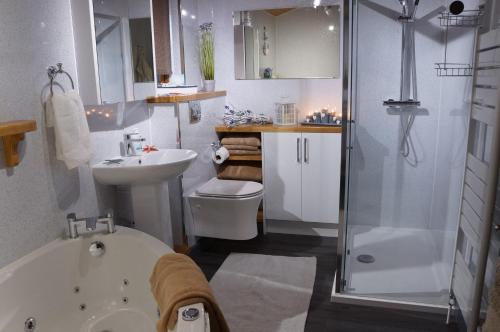 y baño con bañera, lavamanos y ducha. en West Horizon holiday cottage, en Lochinver