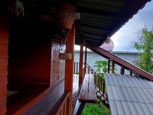 a porch of a house with a view of the water at เฮือนไม้ชมนาด Huanmaichommanard in Chiang Mai