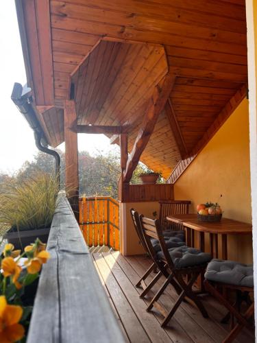 a wooden porch with a table and chairs on a deck at BeeWood apartment in Križe