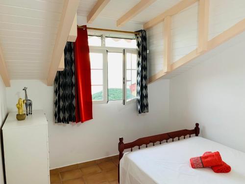 a bedroom with a bed and a window at PARADIS AU SOLEIL, vue panoramique sur mer in Bouillante