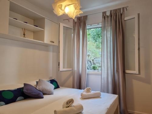 a bedroom with two beds and a window at Holiday Home Prišćapac in Prizba