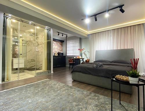 a bedroom with a bed and a glass shower at Студия в современном стиле in Pavlodar