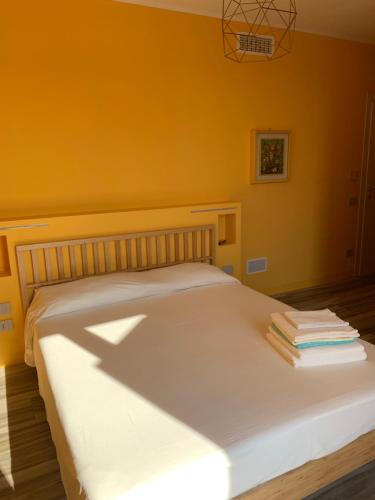 a bedroom with a white bed with yellow walls at Sala dell Estate Guest House in Secchia