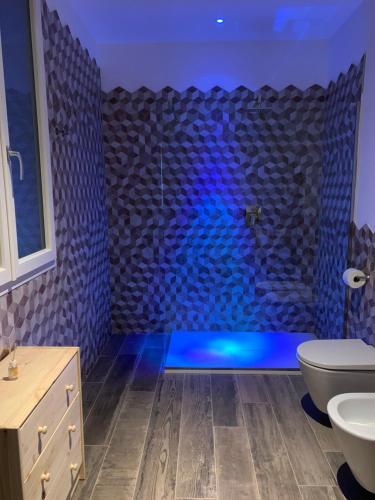a bathroom with a shower with blue lighting at Sala dell Estate Guest House in Secchia