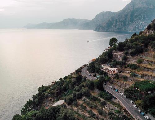 a road on a hill next to a body of water at Hotel Pellegrino in Praiano