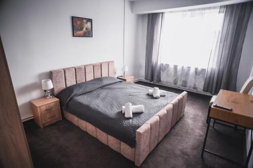 a bedroom with a bed with two teddy bears on it at Petrosani Camere de Inchiriat - Hotel Petroshani srl in Petroşani