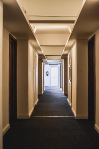 a hallway in an office building with a hallway leading to a door at Petrosani Camere de Inchiriat - Hotel Petroshani srl in Petroşani