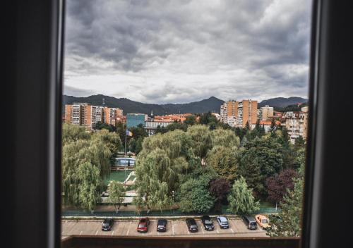 a view of a city with cars parked in a parking lot at Petrosani Camere de Inchiriat - Hotel Petroshani srl in Petroşani