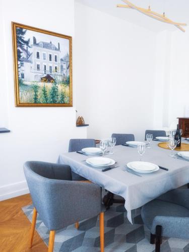 a dining room table with chairs and a painting on the wall at Manoir 1838 à - 3 km du Zoo de Beauval & proche des châteaux in Saint-Aignan