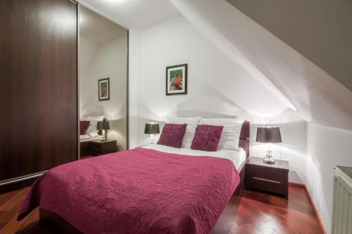 a bedroom with a large bed with a purple blanket at ApartSerwis - Gorące Źródła Apartament Lodowa Kopa 1 in Zakopane