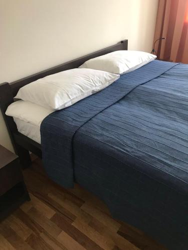 a bed with a blue blanket and white pillows at Best Apartment Truskavets in Truskavets
