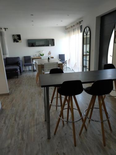 a living room with a dining room table and chairs at logement atypique in Arles