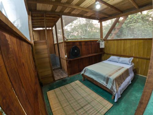 a bedroom with a bed in a wooden house at Green House Tambopata in Puerto Maldonado