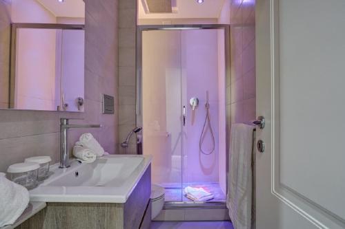 bagno con lavandino e doccia con illuminazione viola di Spagna Boutique a Roma