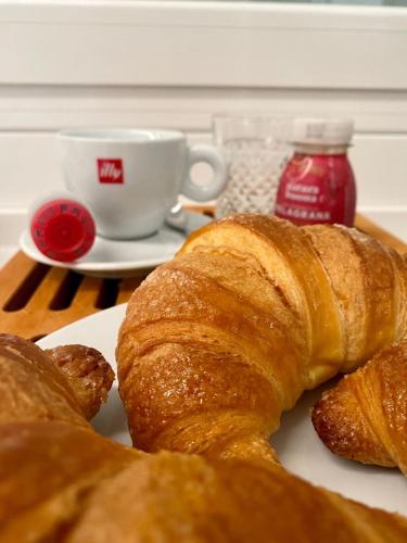 a plate of croissants and a cup of jam and a cup of coffee at Antica Pusterla Relais de Charme in Vicenza